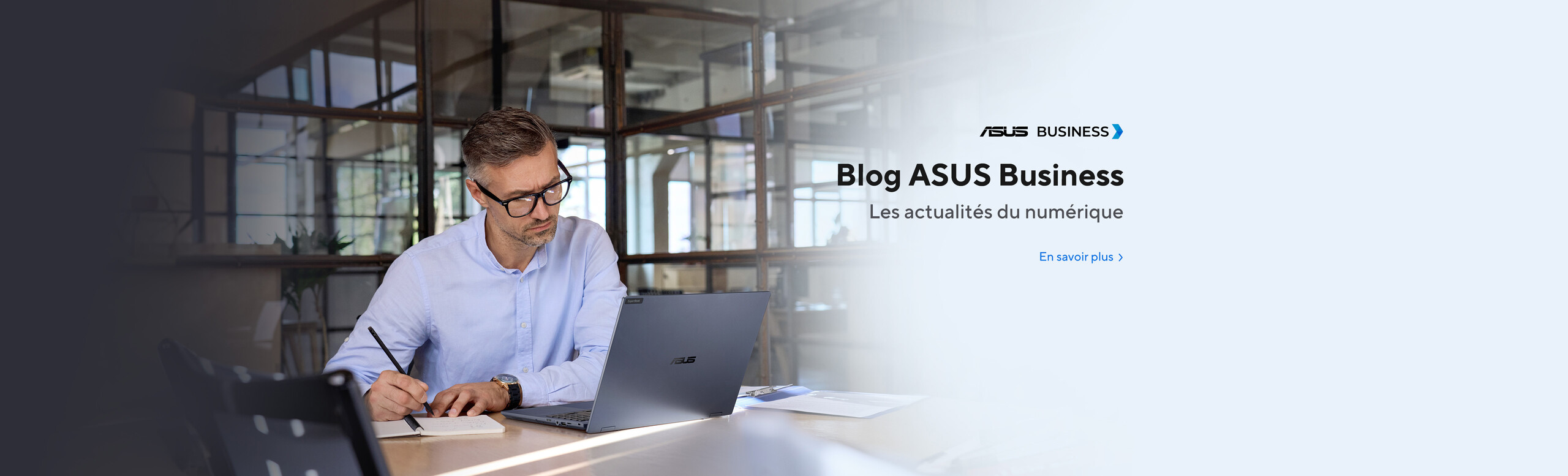 Blog Asus Business. Les actualités du numérique. Un homme en chemise travaillant dans un bureau avec un ordinateur Asus sur un bureau