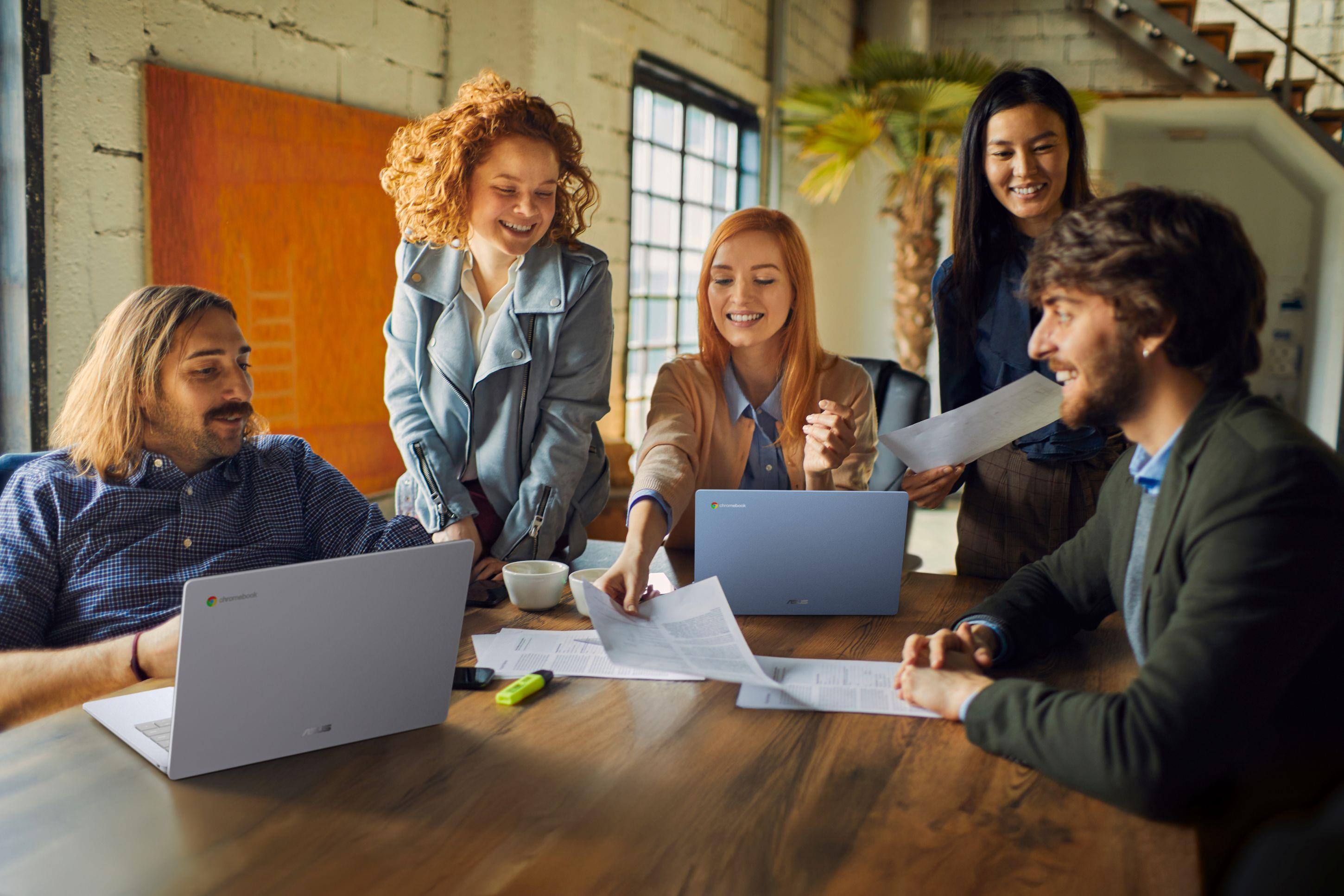 Five people in an office environment using ASUS laptops for work